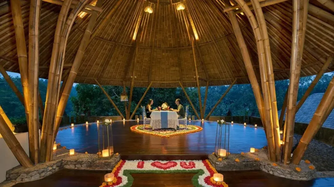 Candlelit private dinner for two inside a bamboo dome pavilion with flower petals, Bali